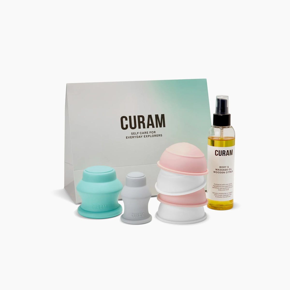 Curam Body Kit Large med pastellfärgad silikonkoppningsuppsättning i mintgrön, ljusrosa och vitt, presenterad med Wooden Citrus massageolja och minimalistisk märkt presentförpackning.