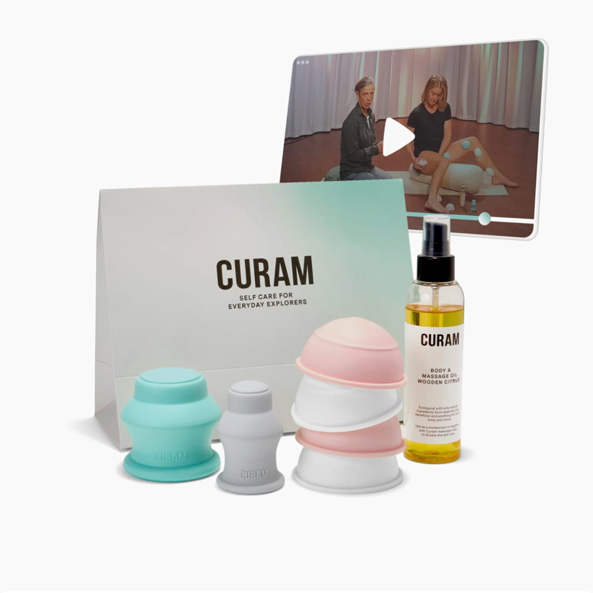 Curam Body Cupping Starter Kit med silikonkoppar i pastellfärgerna mintgrön, rosa och vit, Wooden Citrus massageolja, minimalistisk förpackning och en digital skärm som visar en guidad onlinekurs där en instruktör demonstrerar koppningsteknik.
