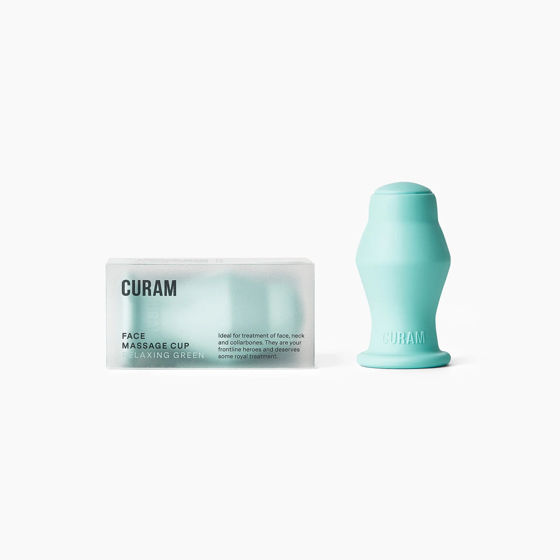 Curam Face Cup i silikon i färgen relaxing green bredvid sin minimalistiska förpackning mot en ren vit bakgrund, som visar ansiktskoppens ergonomiska böjda form och mjuka matta yta.