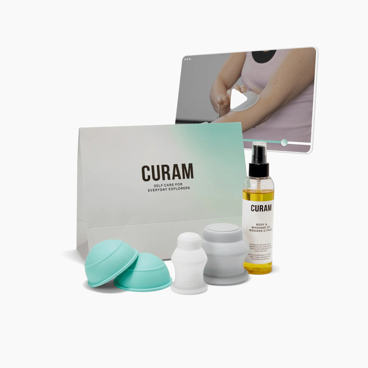 Curam Recovery Kit med turkosa och vita silikonkoppningskoppar, flaska massageolja, märkt förpackning och en videohandledningsskärm som visar en demonstration av koppningsteknik på en arm.